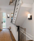 2-Pack Dope Modern Bath Vanity Light Fixtures With Seeded Glass Sconces illuminating a hallway with black railing and carpet