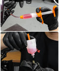Hydraulic Bike Brake Bleed Kit For Shimano, SRAM, Tektro, And Magura in use with visual oil cup and adapters on MTB