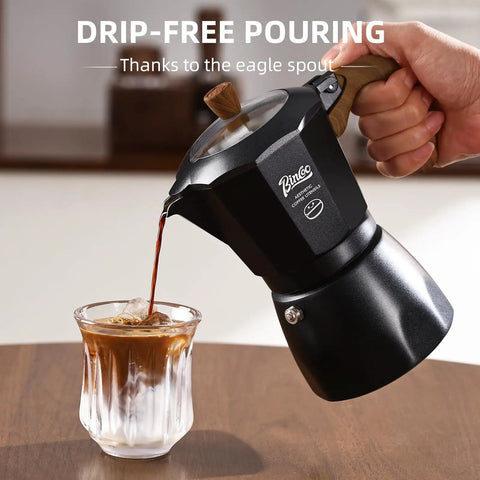 Stovetop Espresso Maker With Double Valve Tech Italian Moka Pot brewed fresh pouring espresso into glass with ice.