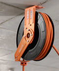 Heavy Duty Retractable Air Hose Reel Winds Sixty Five Feet Of One Half Inch Rubber Tubing featuring auto rewind mounted on ceiling.