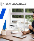 Wireless Laser Printer For Small Teams With Fast Black And White Printing Scanning And Copying Easy Setup And Mobile Printing Budget Friendly Compact MFP Built For Home Office Or Tiny Teams shown on a desk next to a man reading.