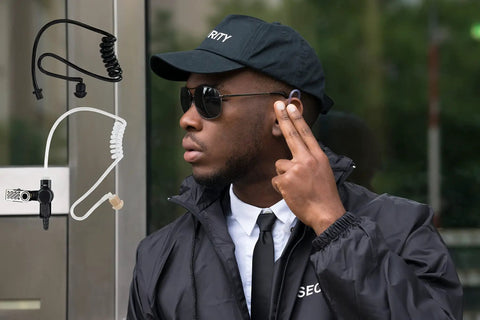 Hella Reliable Wireless Bluetooth Lapel Microphone With Integrated Push To Talk For Radios Phones And Tablets used by a security personnel.