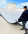 Two workers applying Super Heavy Duty Waterproof Aluminum Foil Tape on a flat roof for sealing and leak prevention.