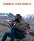 Person using Multi Function Hiking Compass With Ruler And Mirror Luminous Orienteering Survival Tool in snowy mountains.