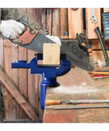 Heavy Duty Universal Bench Vice Machine Vise Clamp For Woodworking And DIY Projects Full Metal Construction With Large Anvil Super Stable Clamping Force Perfect Grip Tools holding a wooden piece while being cut with a saw.