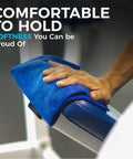 Hand using blue microfiber towel on gym equipment, highlighting comfort.