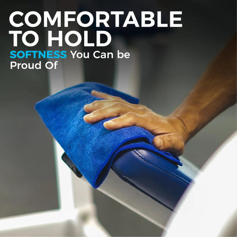 Hand using blue microfiber towel on gym equipment, highlighting comfort.