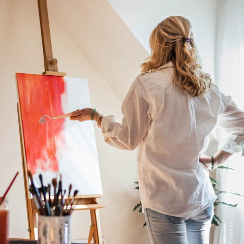 Woman using a Professional Heavy Duty Rubber Ink Roller For Printmaking And Canvas Painting on an easel.