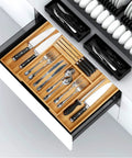 Natural Bamboo Utensil Drawer Organizer Expandable Cutlery Tray With Seven Flexible Slots filled with knives and utensils in a kitchen drawer.