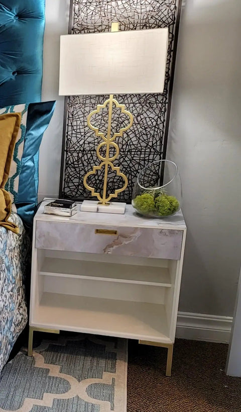 White nightstand with lamp, accented by brushed gold elements and decorative items, featuring 6 Inch Brushed Gold L Top Metal Furniture Legs Set of 4.
