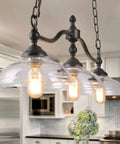 Farmhouse Chandelier Hanging Light Fixture In Rustic Black Metal With Three Bowl Shaped Clear Glass Shades in kitchen
