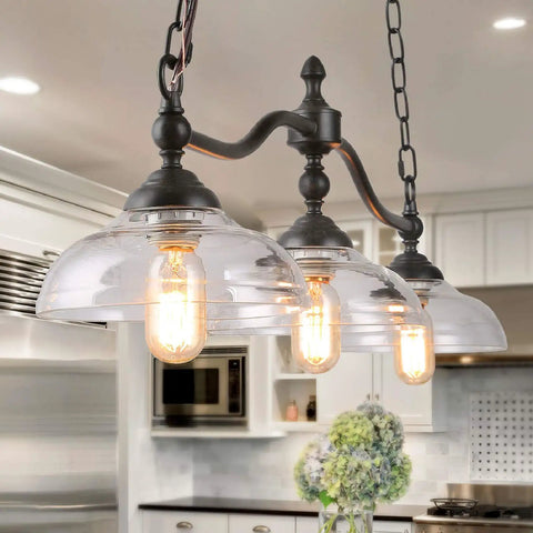 Farmhouse Chandelier Hanging Light Fixture In Rustic Black Metal With Three Bowl Shaped Clear Glass Shades in kitchen