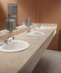 Commercial M Dura Widespread Lavatory Faucet 2.2 GPM Chrome Finish Solid Brass on modern restroom sink, view from the side