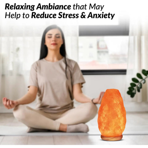 Woman meditating next to Himalayan Glow Natural Pink Salt Lamp Hand Mined In The Himalayan Mountains Crystal Night Light With ETL Brightness Dimmer Switch Wooden Base 6 To 8 Lbs Salt Lamp Calming Amber Glow Gift Box Included