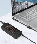 90W Universal Laptop Charger With 16 Tips For Dell, HP And Acer - 100-240V Input - 15V 16V 19V 19.5V 20V Output - Safe Travel Power Adapter For Work, Home, And On The Go. Black power adapter connected to silver laptop