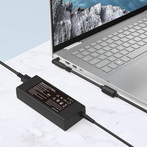 90W Universal Laptop Charger With 16 Tips For Dell, HP And Acer - 100-240V Input - 15V 16V 19V 19.5V 20V Output - Safe Travel Power Adapter For Work, Home, And On The Go. Black power adapter connected to silver laptop