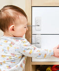 Baby touching cabinet with 3 Pack No Drill Cabinet And Window Locks With Adhesive Mount ABS and Steel Safety Locks visible