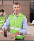 Man wearing 30 Pack Reflective Hi Viz Safety Vests For Men And Women, Mesh Adjustable Work Vests With Neon Green Strips in warehouse