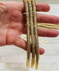 Top Shelf 8mm Gold Disc Brass Spacer Beads Featuring Gleaming 14K Gold Plated Finish held in hand for jewelry making.