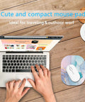 Person using laptop with Compact 6x7 Inch Mouse Pad for Laptop and Keyboard Tray, cyan blue marble design, on wooden desk.