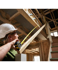 Person using Fatmax Autolock Tape Measure 8m Metric Only Yellow Black, Reverse Lock for one-handed control in construction site
