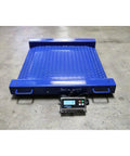 Badass Industrial Drum Scale Featuring Smooth Rolling Ramps Hella Rugged Platform Weighs Two Thousand Five Hundred Pounds in blue with display.