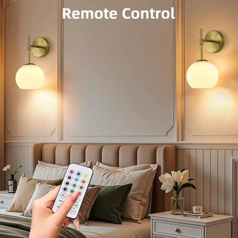 Battery Operated Wall Sconces Set Of Two Rechargeable Gold Milk Glass Wireless Lighting shown with remote control in a cozy bedroom.