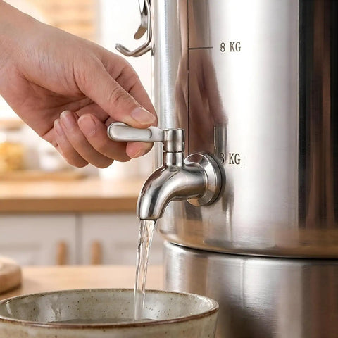 Hand operating the spigot of a Straight Up Heavy Duty 304 Stainless Steel Beverage Dispenser pouring liquid into a bowl.