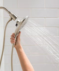 Person holding Engage Brushed Nickel Magnetic Handheld Shower Head With Six Functions And Magnetic Docking System spraying water