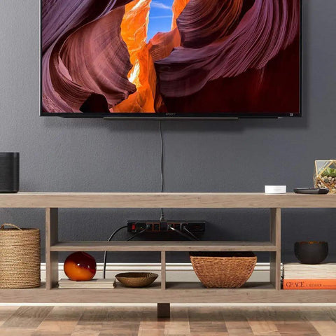 Living room setup with TV, wooden table, and Rotating Surge Protector Power Strip With Six Swivel Outlets And Two USB Ports, 1080 Joules Of Surge Protection, Extra Long Cord, Wall Mount Holes, Space Saving, No Brainer Setup For Home Office Or Entertainment Center underneath.