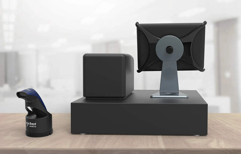 Desktop setup with Charging Dock For 600 And 700 Series Scanners USB Powered Cradle shown beside a monitor stand on a wooden desk