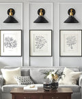 Two Adjustable Matte Black Wall Sconces With Gold Stem, Gallery Hallway Lighting above artwork in modern living room