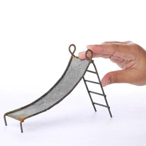 Miniature Rustic Metal Slide For Fairy Garden Bench And Backyard Micro Landscape Set featuring a hand for size reference.