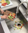 Person using Half Horsepower Batch Feed Garbage Disposer For Home Kitchen With Easy Install Kit And Non Corded Design Grinds Cooked Meat Beans And Seeds Fast No Jam Performance Ideal For 2 To 4 Person Households High RPM And Low Jamming