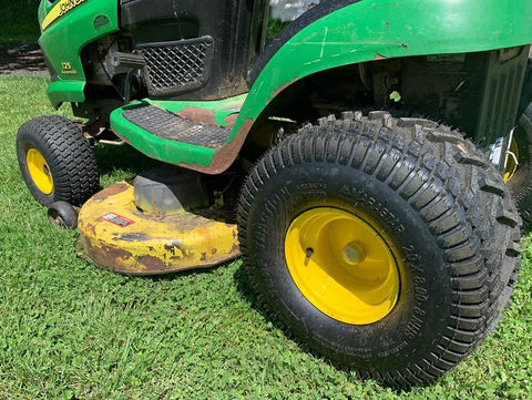 Side view of Tubeless Pneumatic Tire and Wheel Assembly 20x8.00-8 Turf Traction Tread For Riding Mowers Replacement Rear Tire 2 Pack Fits John Deere Lawn Tractors Compatible, installed on a green lawn tractor.