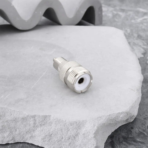 Silver UHF SO239 Female To RCA Male Coax Connector Adapter for Ham Radios on stone surface