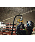 Worker using a Heavy Duty Cordless 20V Brushless Rotary Hammer Drill Sick Power Bad Boy for concrete drilling overhead on-site.