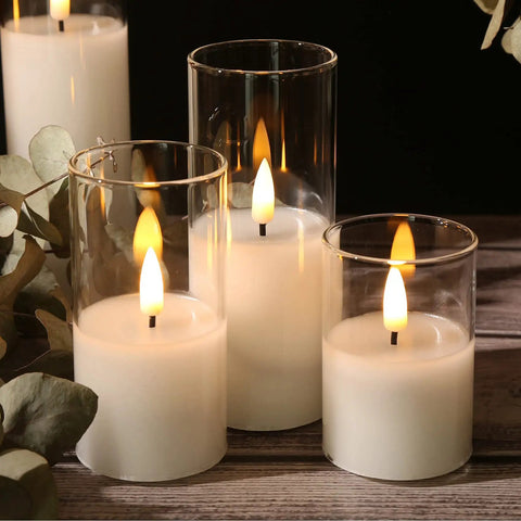 Clear Glass Flameless Candles With Remote Set Of 5 Slim Tall LED Pillar Candles Battery Powered Assorted Sizes on wood table