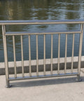 Heavy Duty Outdoor Railing Guardrail For Balcony And Deck Crafted From Top Shelf 304 Stainless Steel on a concrete walkway by water