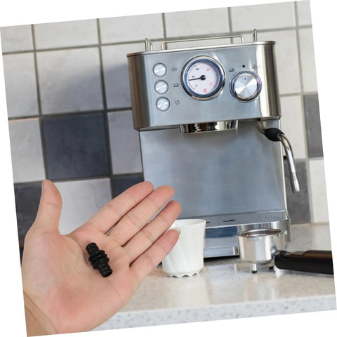 Person holding Replacement Heat Insulation Tube for Steam Wand next to espresso machine, showing size and application