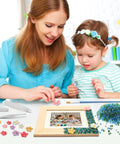 Mother and child using Mosaic Photo Frame Kit For Kids With Glass Pebbles, Hands On Arts And Crafts Activity on wooden frame.