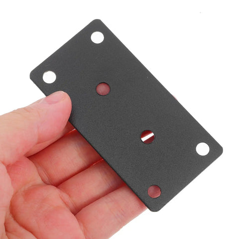 Hand holding matte black heavy duty stainless steel corner brace for wood shelves with holes for screws.