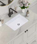 Rectangular Ceramic Undermount Bathroom Sink for Vanity 20 by 16 White Vitreous China Sleek Ultra Smooth Finish With Overhang Cutout Template Exterior 19 and a Half by 15 and a Half One Year Limited Warranty installed in a marble countertop with faucet and decor.