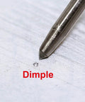Close-up of No Sweat Hammer Free Automatic Center Punch With Twist Dial Tension And Razor Sharp Carbide Tip on marked dimple.