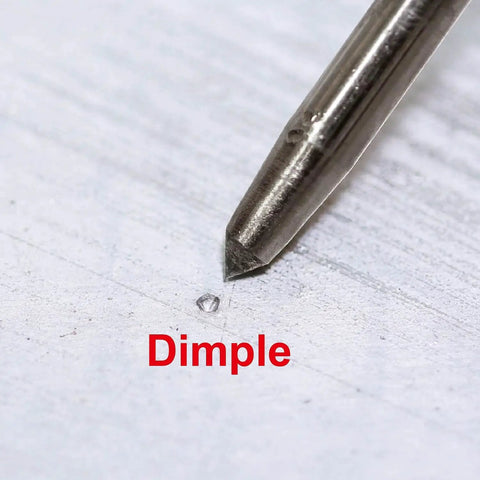 Close-up of No Sweat Hammer Free Automatic Center Punch With Twist Dial Tension And Razor Sharp Carbide Tip on marked dimple.
