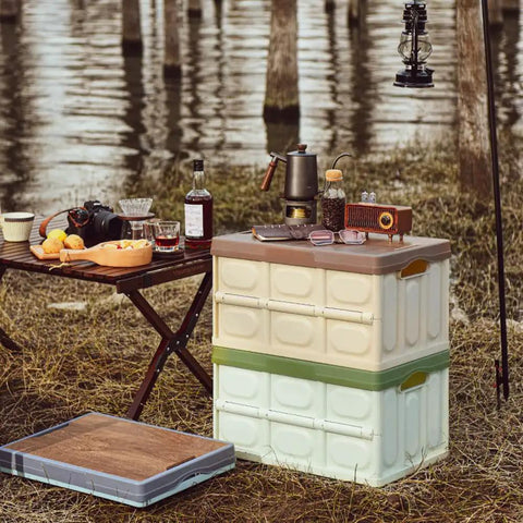 Heavy Duty Collapsible Storage Bins With Lid, Tough Camping Organizer Box For Car Trunk And Groceries, Converts To A Rock Solid Sitting Stool, 50 Liter Green Bin displayed at a campsite with drinks and snacks.