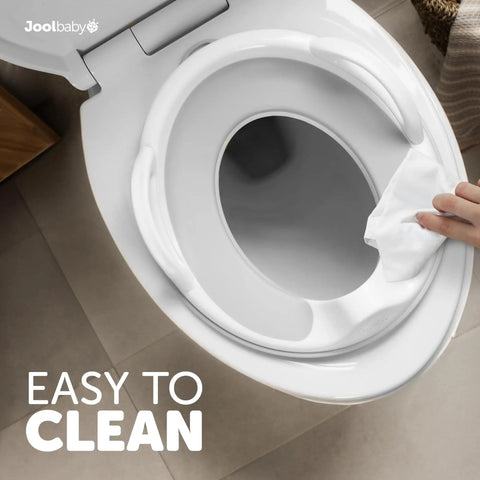 Toddler Potty Training Seat With Sure Grip Handles And Non Slip Base For An Easy Peasy Transition To The Big Toilet Includes Splash Guard Plus Handy Wall Hook Gray being wiped clean.