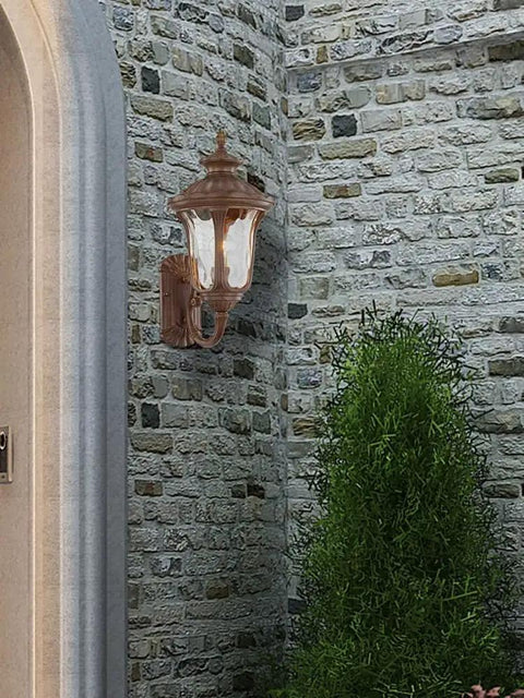 Oxford Style 1 Light Imperial Bronze Cast Aluminum Wall Lantern with Amber Water Glass on brick wall outdoors