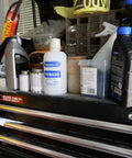 PhysiciansCare Eye Wash bottle, 16 oz, white plastic with blue label, front view on a toolbox shelf.