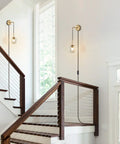 Plug In Wall Sconce Set Of 2 Modern Glass Globe Lights With Brushed Brass Finish in a staircase hallway